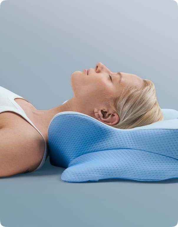 A back sleeper lying with the head in the pillow's centre dip and the raised ridge beneath the neck