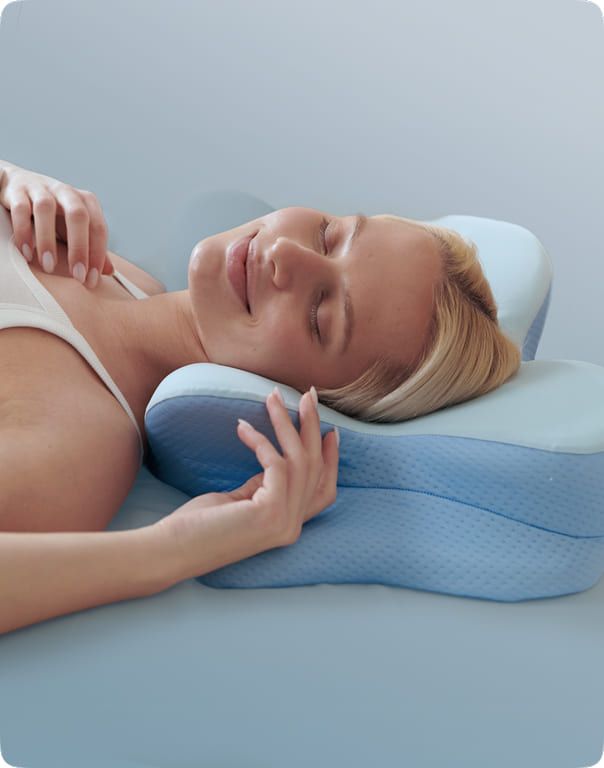 A side sleeper with one arm resting in the cut-out section along the edge of the pillow